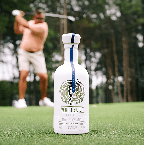 Whiteout tequila bottle on a golf course with a golfer in the background